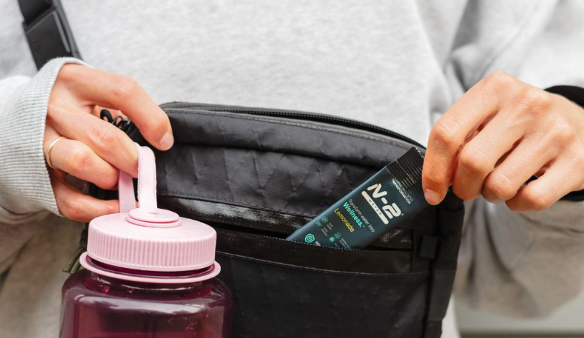 An N-2 stick tucked beside a water bottle in a packed gym bag